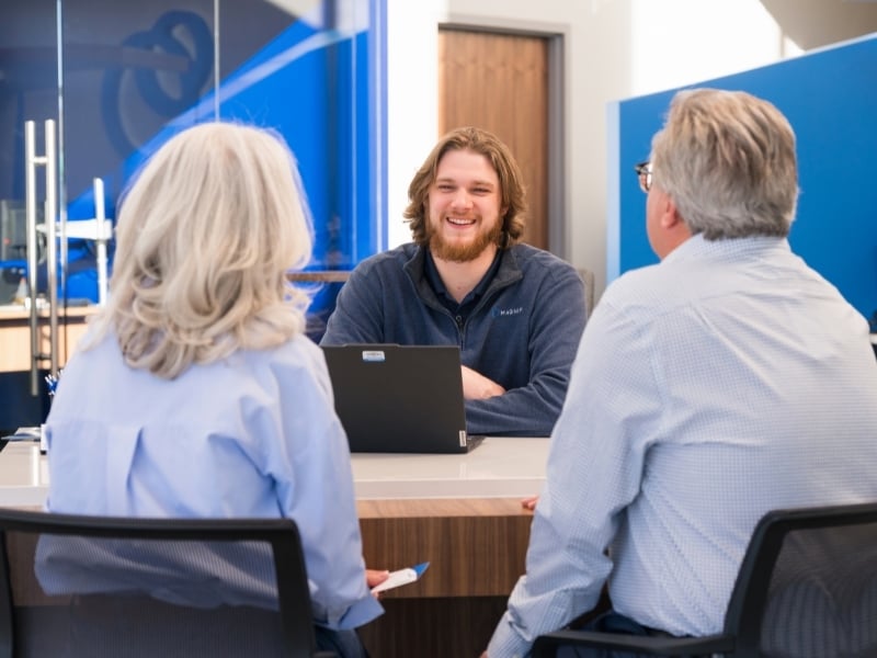 Magnifi employee sitting with members to discuss finances.