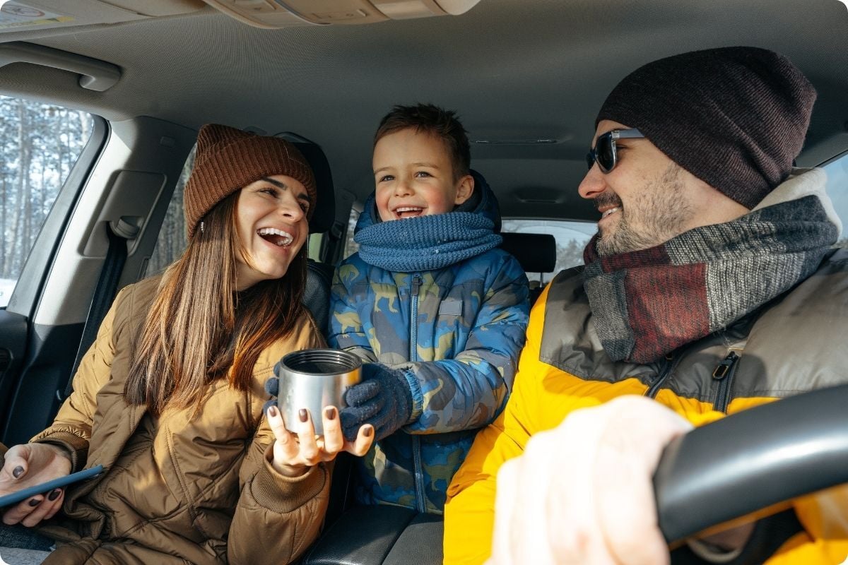 Happy Mom and Dad enjoying hot chocolate with son.