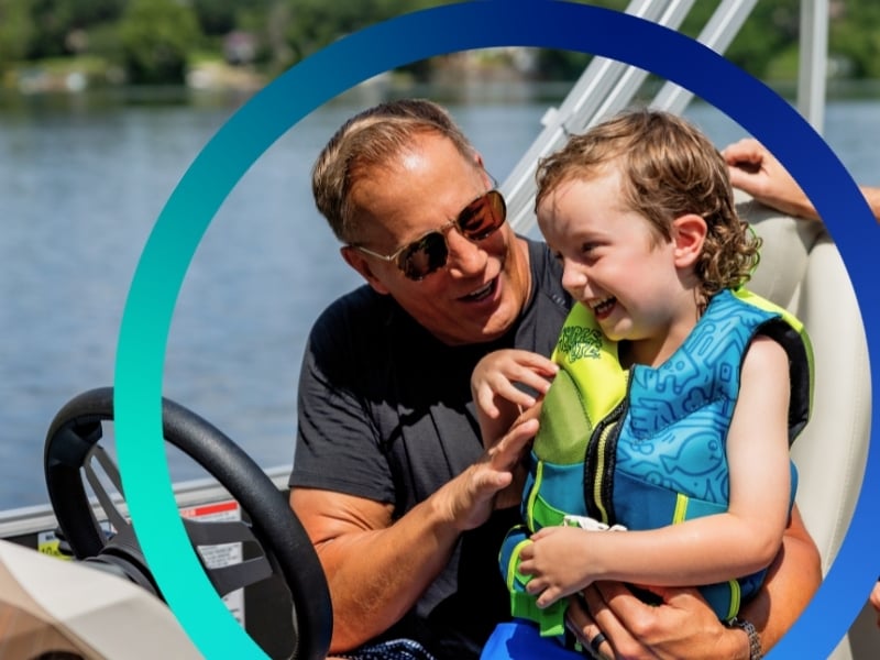 Grandpa and grandson on pontoon.