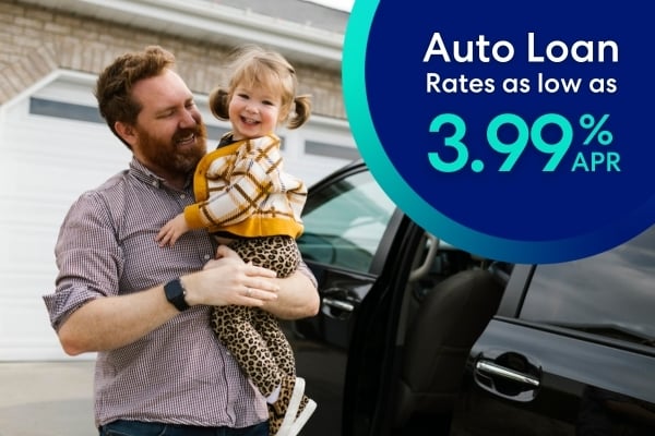 happy dad holding daughter outside minivan.